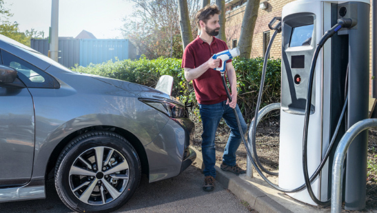 image of man charging electric car